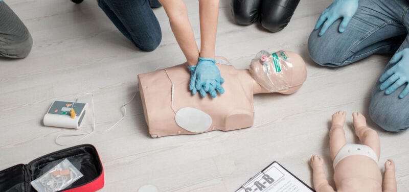 person performing first aid on a dummy in a demo