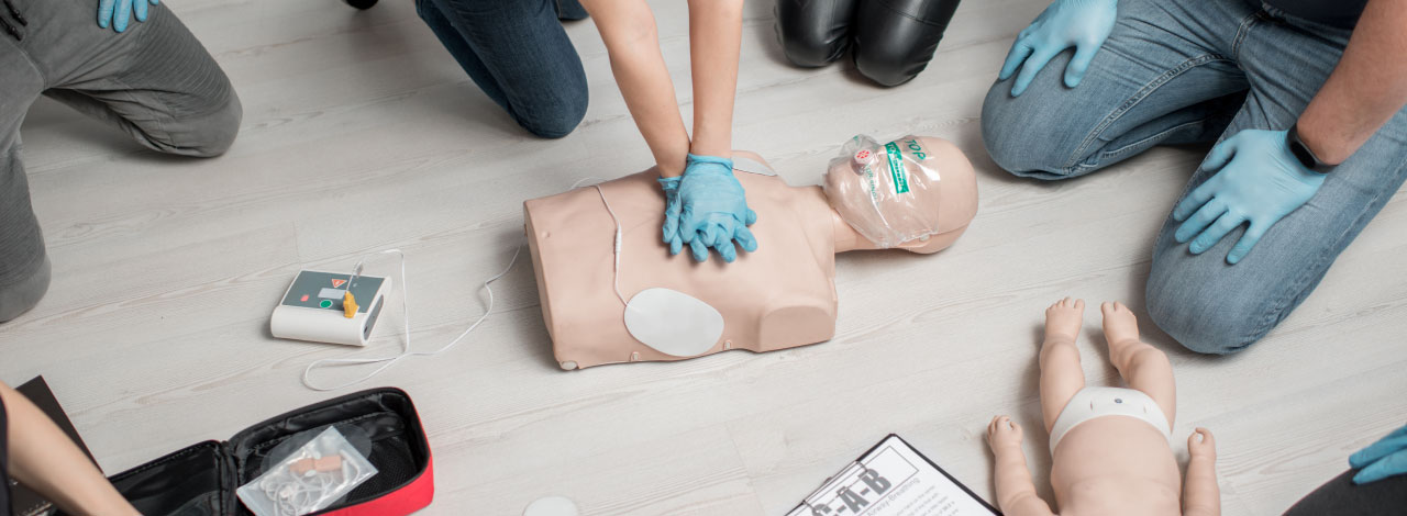 person performing first aid on a dummy in a demo